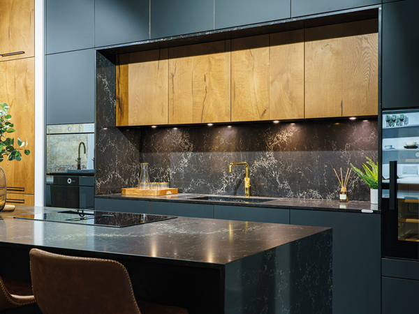The Keller Gouvia matte black kitchen is combined with Nottingham stained wood in Smoke Oak, and a 20mm Ceasarstone Vanilla Noir surface